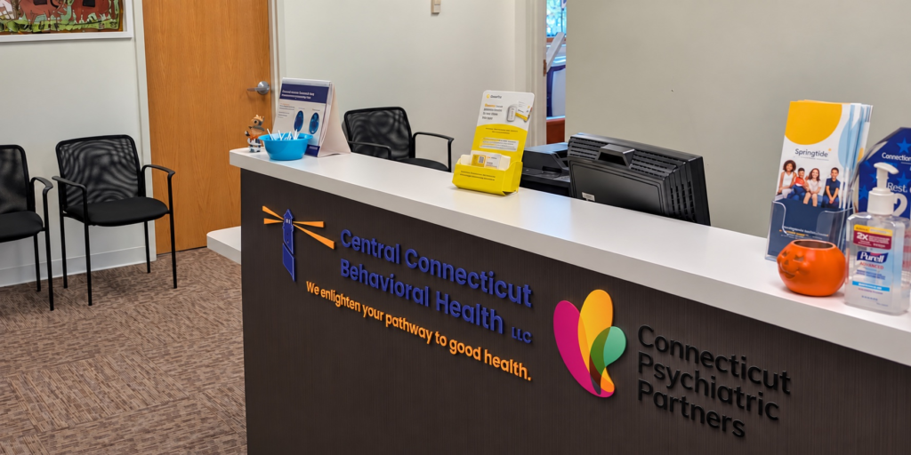 Reception desk displaying Central Connecticut Behavioral Health and Connecticut Psychiatric Partners logos at the West Hartford office